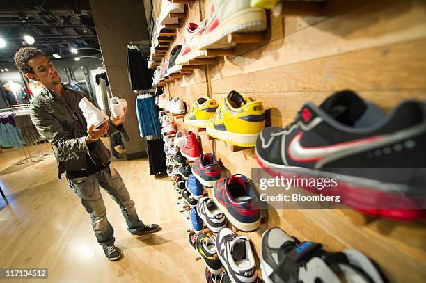 Ariel Perez of Cuba shops for shoes at Nike Inc.'s Niketown store in downtown San Francisco, California, U.S., on Thursday, June 16, 2011. Retailers...