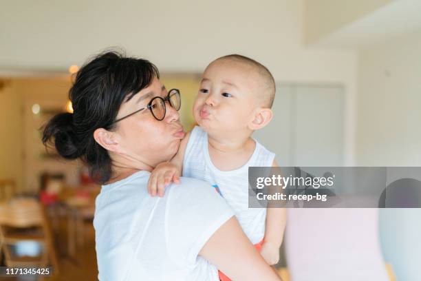 mother and baby boy making funny face - funny face baby stock pictures, royalty-free photos & images