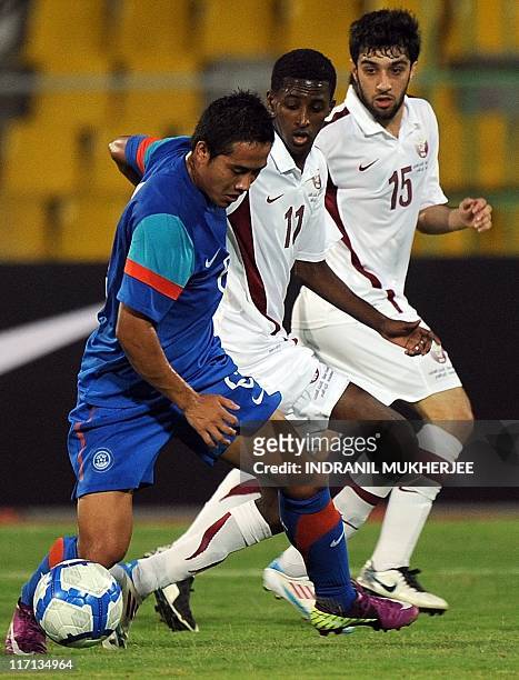 Jeje Lalpekhlua of India dribbles past Qatar's Mohamed Salah M H Elneel and Khaled Muftah during the second leg of their 2012 London Olympic Asian...