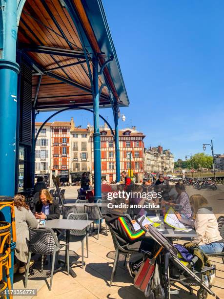 people relaxing outdoors in a cafe in bayonnes, france - bayonne stock pictures, royalty-free photos & images