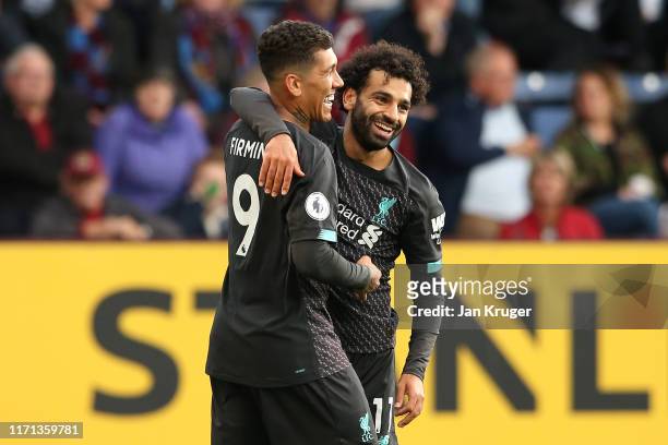 Roberto Firmino of Liverpool celebrates with teammate Mohamed Salah after scoring his team's third goal during the Premier League match between...