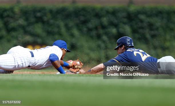 Christian Yelich of the Milwaukee Brewers steals second base in front of Addison Russell of the Chicago Cubs during the third inning of a game at...