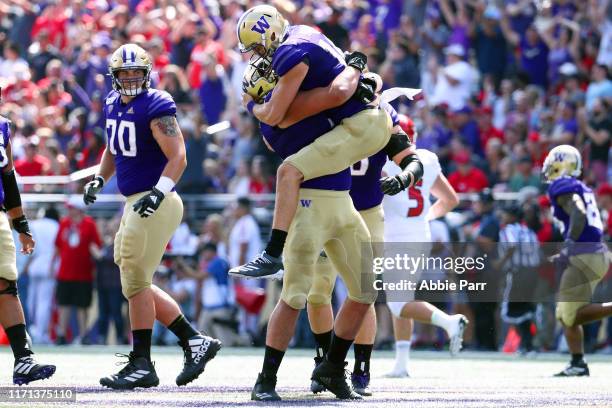 Jacob Eason celebrates with Jaxson Kirkland of the Washington Huskies after completing a 50 yard touchdown pass in the first quarter against the...