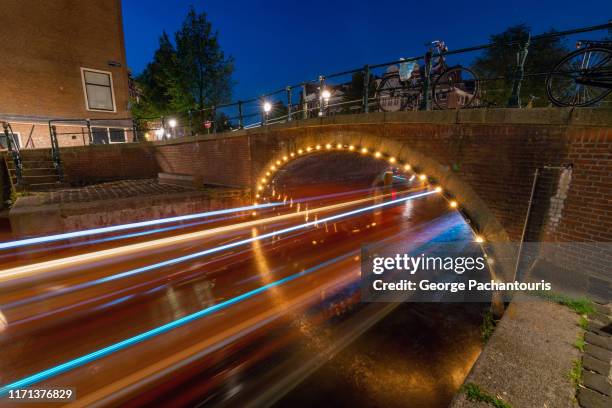 lights of a boat moving fast under a bridge in amsterdam - noord holland landschap stockfoto's en -beelden