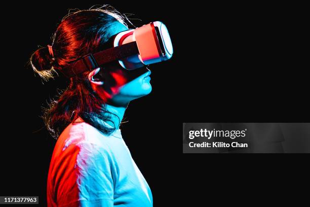 woman using virtual reality headset at night - vr photos et images de collection