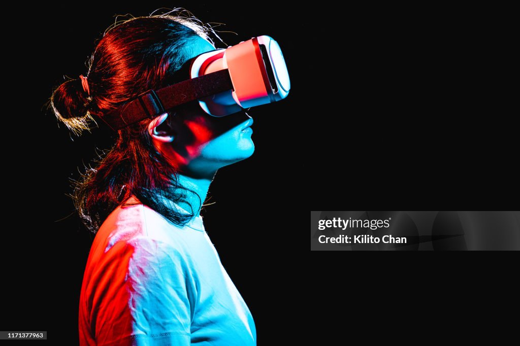 Woman using Virtual Reality headset at night