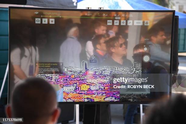 Attendees are reflected in a large screen display of the pilot's user interface from the new FLIR C360 Muve multi-gas detector aboard a DJI Matrice...