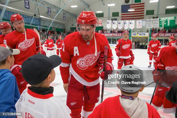 Dylan Larkin of the Detroit Red Wings gives a jersey to a young fan after a pre-season Kraft Hockeyville game against the St. Louis Blues at the...