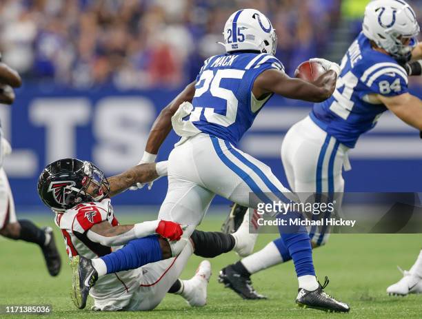 Marlon Mack of the Indianapolis Colts runs the ball as Sharrod Neasman of the Atlanta Falcons attempts the tackle at Lucas Oil Stadium on September...