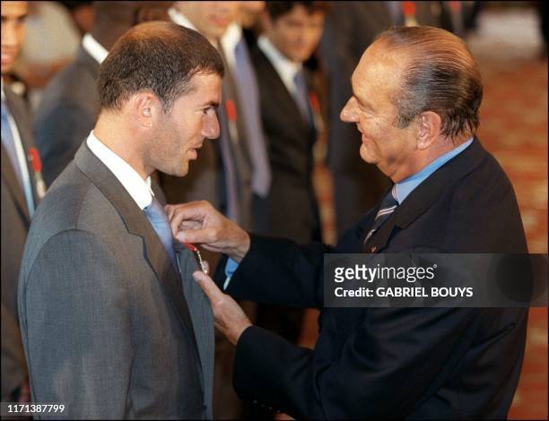 Le président Jacques Chirac décore de la légion d'honneur Zinédine Zidane, le 01 septembre au Palais de l'Elysée à Paris, lors de la cérémonie...