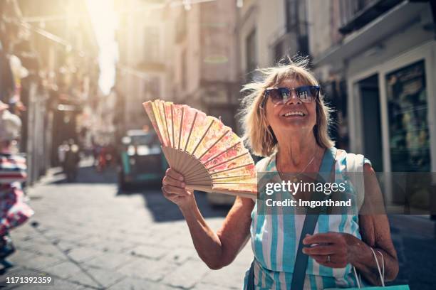 senior woman sightseeing small italian town - hand fan stock pictures, royalty-free photos & images