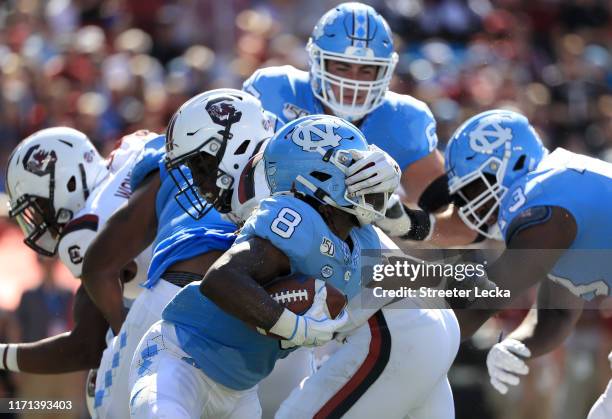 Michael Carter of the North Carolina Tar Heels tries to run with the ball as he is hit by the South Carolina Gamecocks during the Belk College...