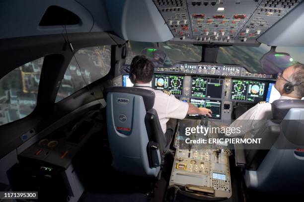 This photograph taken on September 16 shows Air France pilots inside an Airbus A350 flight simulator at the company training centre near Roissy...