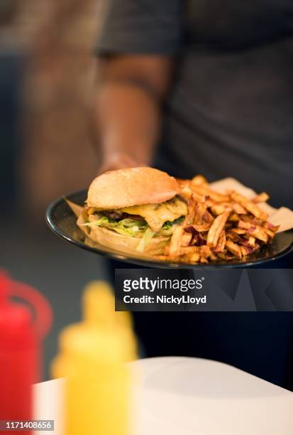 servieren von burger mit chips - fastfood restaurant table stock-fotos und bilder