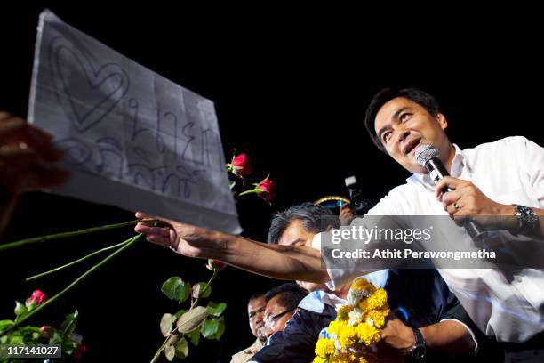 Thai Prime Minister and leader of the Democrat party Abhisit Vejjajiva receives flowers from supporters during a rally held at the site of Red Shirt...