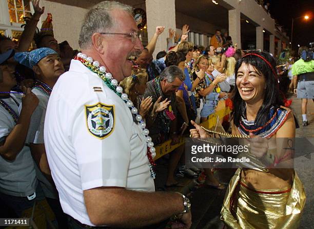 Women tries to put beads around a Key West police officer October 27, 2001 during the Key West, Florida Fantasy Fest. Key West's 10-day Fantasy Fest...