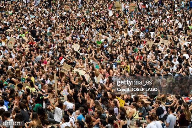 Demonstrators take part in a global youth climate action strike on the Placa Sant Jaume in Barcelona, on September 27, 2019 at the end of a global...