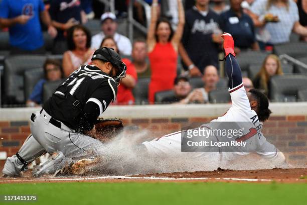 Ozzie Albies of the Atlanta Braves slides safely into home to score in the first inning against the Chicago White Sox at SunTrust Park on August 31,...