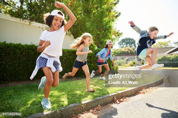 happy kids jump and play outside - approaching stock pictures, royalty-free photos & images