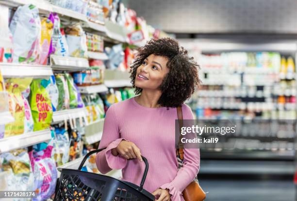 giovane donna afroamericana che fa shopping al supermercato - snack foto e immagini stock