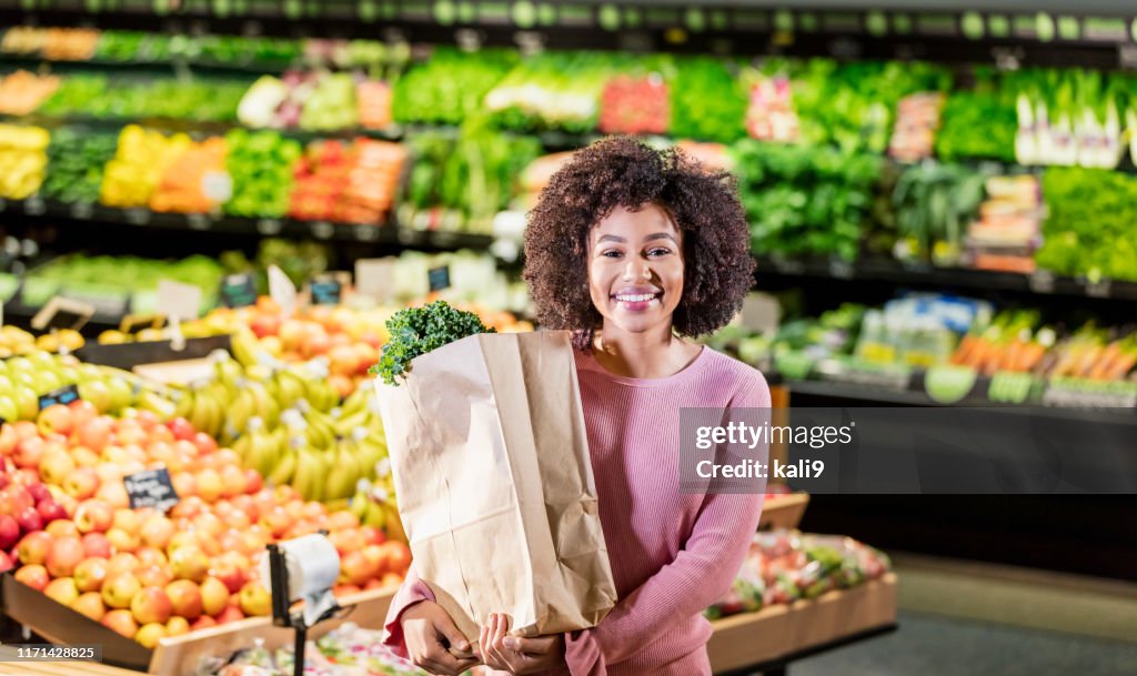 Junge Afroamerikanerin beim Einkaufen im Supermarkt