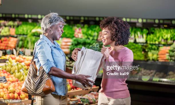 two african-american women in supermarket - shopping friends family stock pictures, royalty-free photos & images