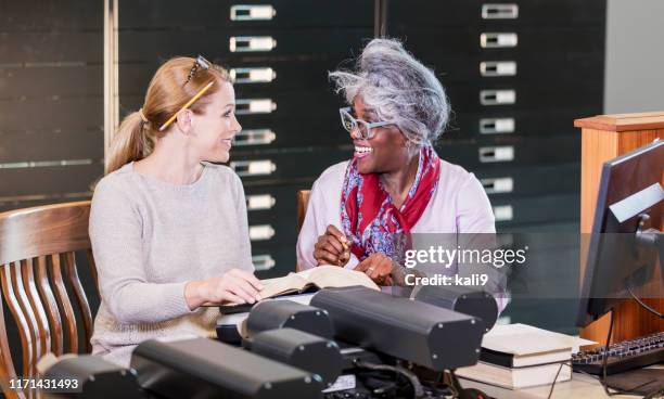 two women in library with microfiche reader - history textbook stock pictures, royalty-free photos & images