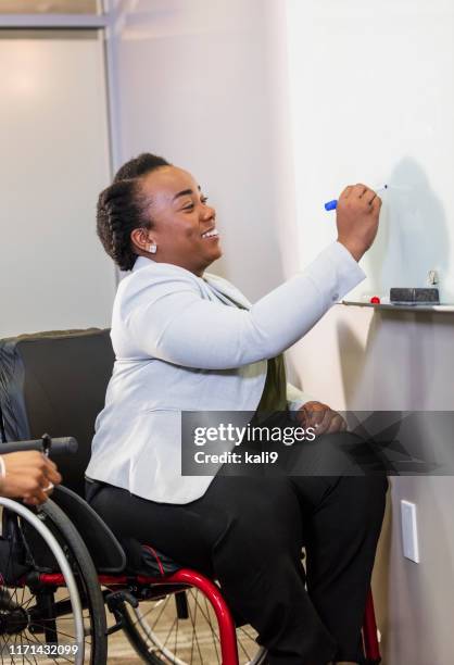 businesswoman in wheelchair at whiteboard - of deformed people stock pictures, royalty-free photos & images