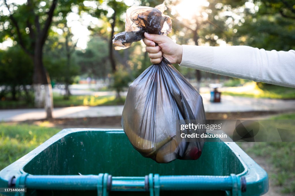 Throw the garbage bag into the trash can