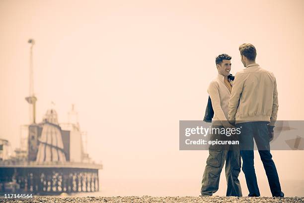 gay male couple on the beach in brighton england - only young men stock pictures, royalty-free photos & images