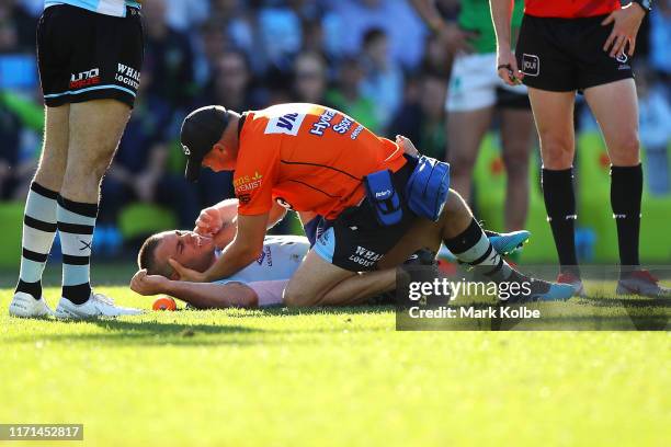 Wade Graham of the Sharks receives attention from the trainer during the round 24 NRL match between the Cronulla Sharks and the Canberra Raiders at...