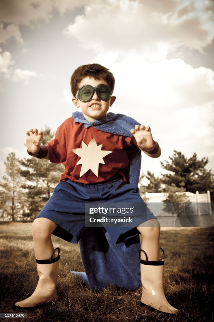 Cross-processed Youth Pretending to be Superhero in Homemade Costume Outdoors