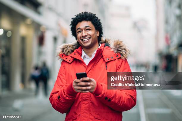 foto di un uomo che usa lo smartphone - red coat foto e immagini stock
