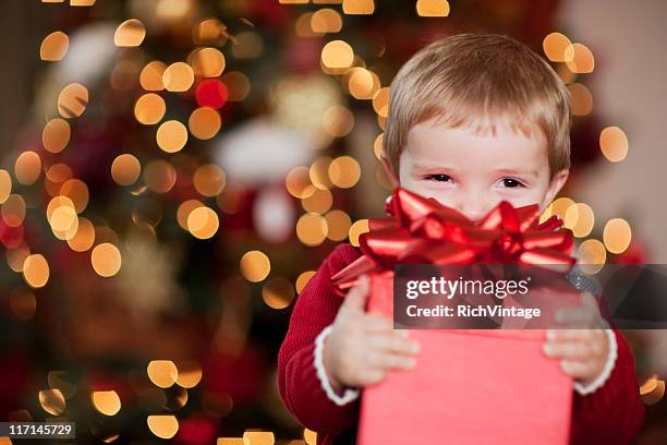 young boy smiles con su regalo de navidad - christmas gift fotografías e imágenes de stock