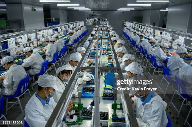 Workers make pods for e-cigarettes on the production line at Kanger Tech, one of China's leading manufacturers of vaping products, on September 24,...