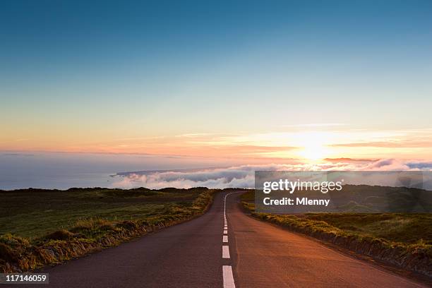 carretera en las nubes al atardecer - camino fotografías e imágenes de stock