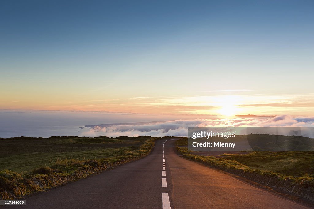 Autoroute au coucher du soleil dans les nuages.