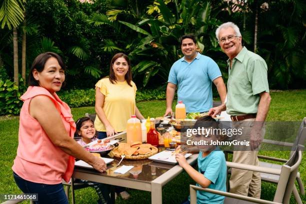 latin american barbecue lunch in lush miami backyard - lush backyard stock pictures, royalty-free photos & images