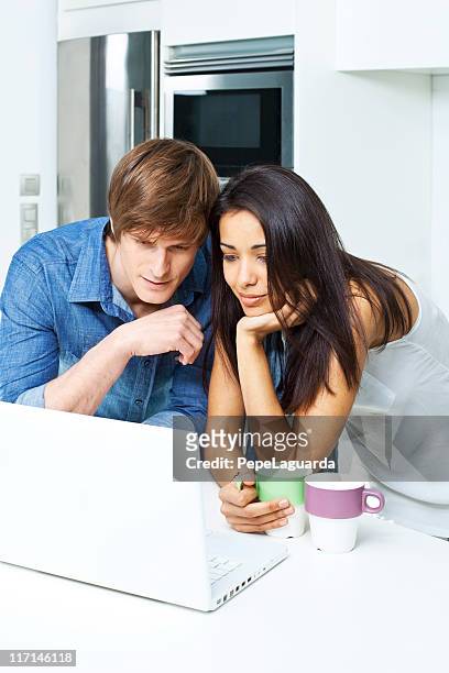 couple at home with laptop. - cool couple in apartment stock pictures, royalty-free photos & images