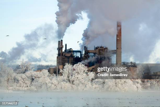 cold reality; factory smoke stacks amid winter wonderland environment - smoking duck stock pictures, royalty-free photos & images