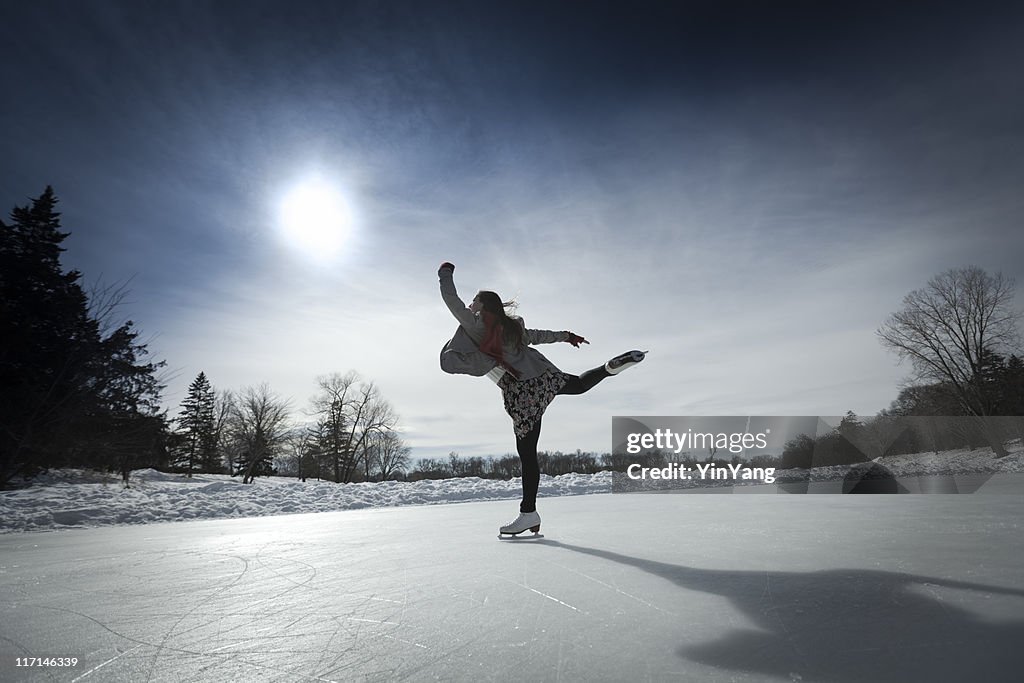 フィギュアスケートアゲインスト太陽のアイススケートリンクで冬の池
