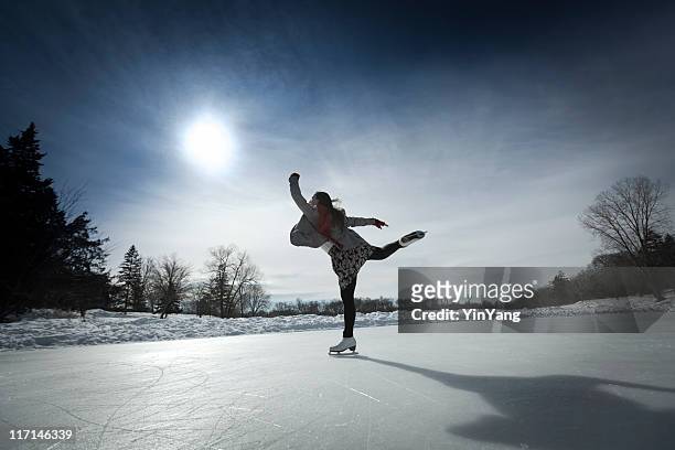 figure skater skating against sun on winter pond ice rink - figure skating girl stock pictures, royalty-free photos & images