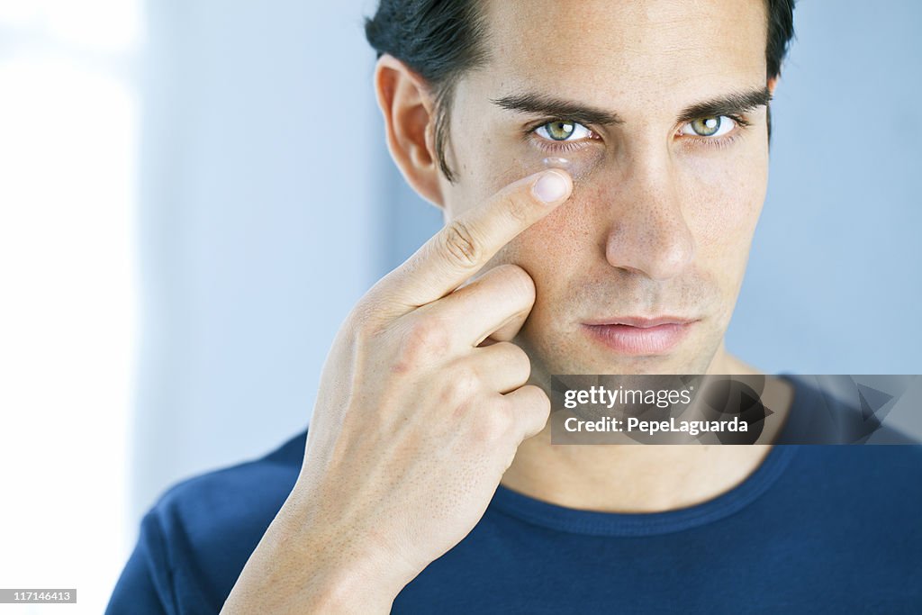 Vision: man using a contact lens