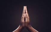 Praying hands with faith in religion and belief in God on dark background. Power of hope or love and devotion. Namaste or Namaskar hands gesture.