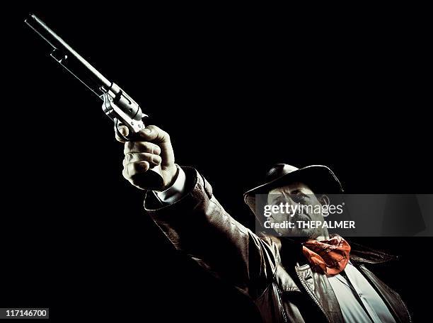 american cowboy aiming a revolver - firing handgun stock pictures, royalty-free photos & images