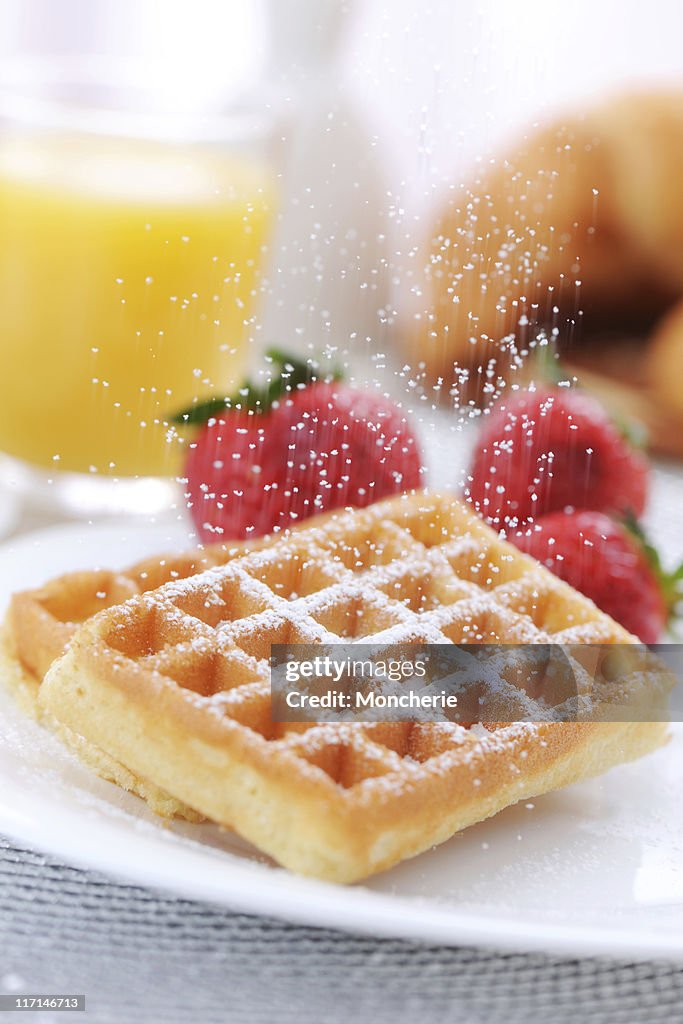 Pouring sugar to waffles