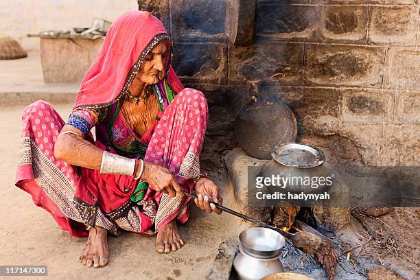 indian senior woman preparing food. bishnoi village. rajasthan. - rajasthani women stock pictures, royalty-free photos & images