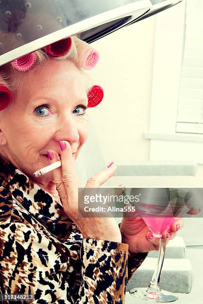 sexy senior woman with attitude wearing rollers in beauty salon - vintage beauty salon stock pictures, royalty-free photos & images