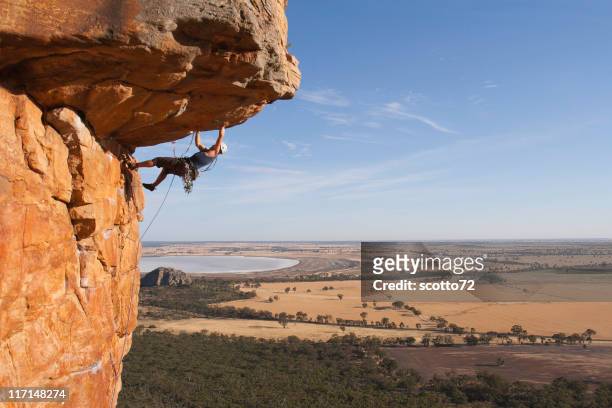 man rock climbing - overhangende rots stockfoto's en -beelden
