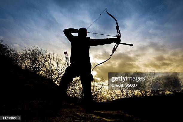 bow hunter silueta en la naturaleza - arco y flecha fotografías e imágenes de stock